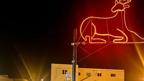 Uno de los adornos navideños todavía iluminado y colocado en  una farola.