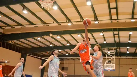 Jugador del CB Conejeros realizando una bandeja en el aro que defiende el 7 Palmas.