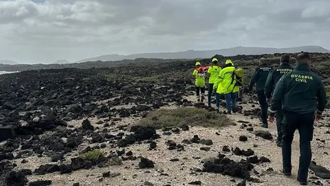 Operarios de EMERLAN junto a la Guardia Civil portando el cuerpo del fallecido.