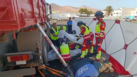 Bomberos durante la operación de extracción del cuerpo sin vida del fallecido de debajo del camión.