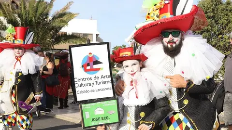 Murga los intoxicados llevan un cartel de los CACT durante un evento del carnaval.