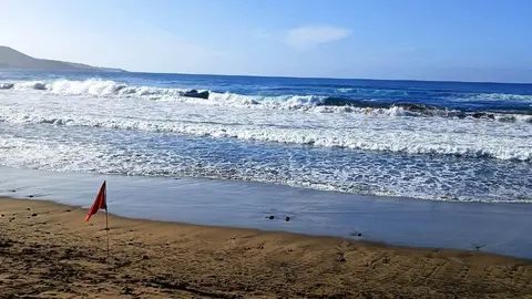 Imagen de una playa de Canarias con bandera roja