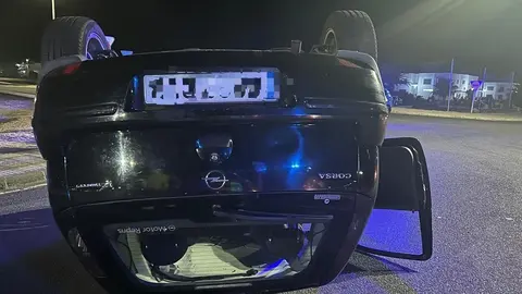 Vehículo volcado tras el choque.