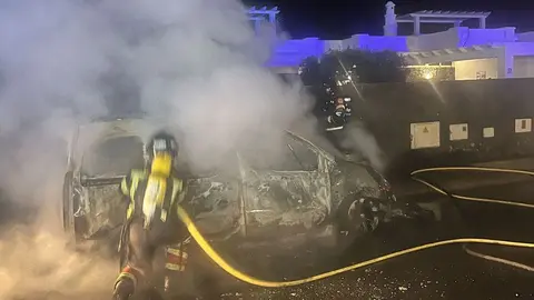Los bomberos en el momento en el que sofocaron el incendio de uno de los vehículos
