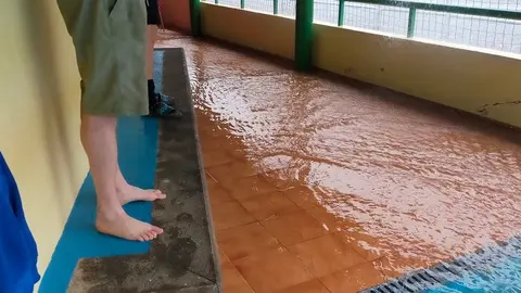 Imagen del bar del campo de fútbol de Tahíche con la gente tratando de refugiarse del lago que se estaba creando en pocos minutos