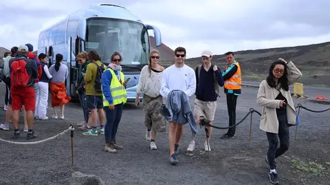 Visitantes bajando en el volcán del Cuervo de la guagua Lanzadera.