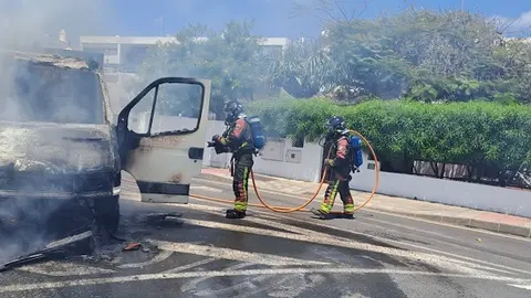Bomberos sofocando el fuego localizado en la cabina del camión.