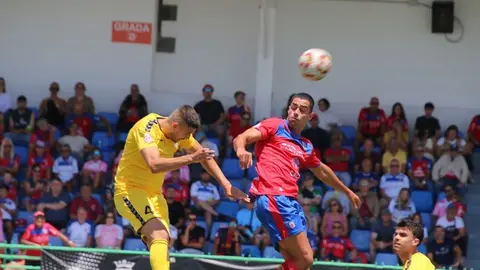 Disputa de un balón aéreo entre los jugadores de los dos equipos