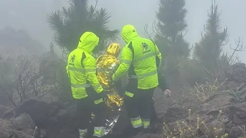 Operarios de EMERLAN realizando el auxilio de un corredor durante el desarrollo de la Transvulcania.