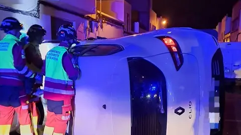 Bomberos del Consorcio de Seguridad y Emergencias junto al vehículo volcado.