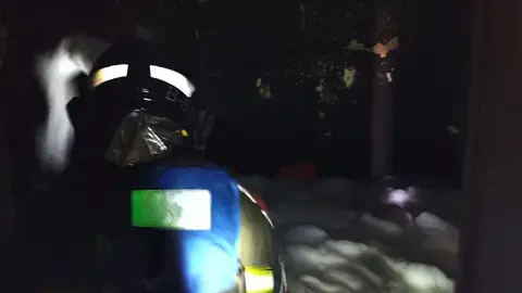 Bombero del Consorcio apagando el fuego localizado en el interior de la vivienda.