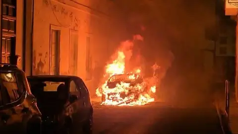 Imagen del vehículo ardiendo al lado de unas viviendas. 