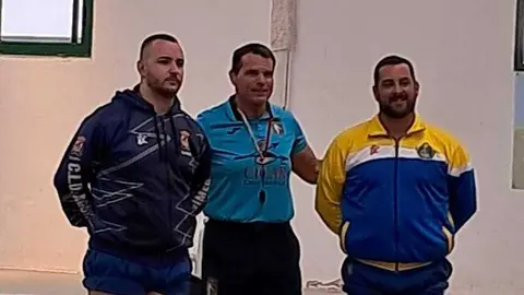 Luchadores del Unión Sur Yaiza y el Agüimes junto al árbitro Juan Carlos Matoso.