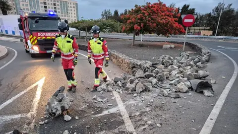 Los bomberos recogiendo las piedras que cayeron tras el fuerte impacto