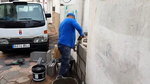 Uno de los operarios del Ayuntamiento tapiando el inmueble.