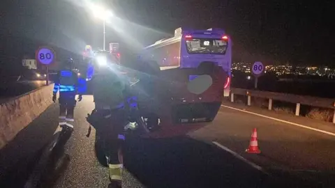 Bomberos del Consorcio de Seguridad y Emergencias junto al vehículo volcado.