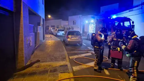 Bomberos junto al sótano afectado por el fuego.