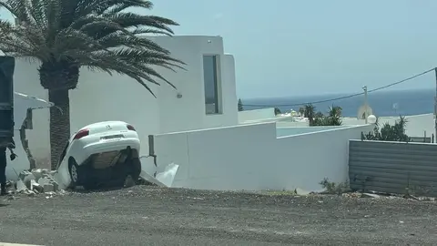 Imagen del vehículo tras chocar contra el muro de la vivienda.