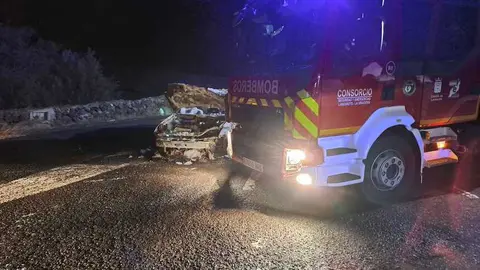 Camión de los bomberos junto al vehículo totalmente calcinado.