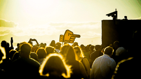 Asistentes al Arrecife en Vivo junto al característico dedo que dirige al público hacia el siguiente escenario.