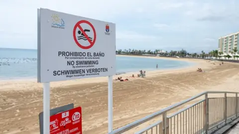 Imagen de este jueves con el cartel de prohibición del baño en la céntrica playa de Arrecife.