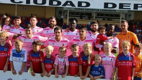 Imagen del equipo titular con los aficionados más pequeños