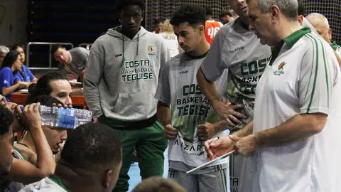 Los jugadores del Costa Teguise escuchando atentos al entrenador.