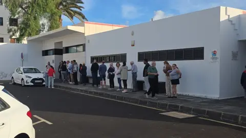 Imagen de la gente haciendo cola para entrar en el consultorio local.