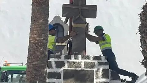 Momento en el que los operarios de la empresa Tiagua colocaron de nuevo la cruz en la plaza.