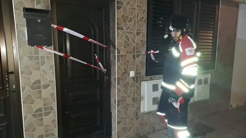 Imagen de uno de los bomberos saliendo de la casa precintada.
