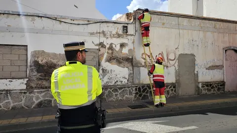 Agentes de la Polic&iacute;a Local de Arrecife en la calle Blas Cabrera Topham para evitar el tr&aacute;nsito mientras los bomberos retiran los cascotes de la fachada de ese inmueble
