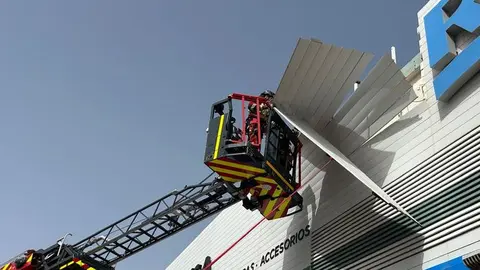 Imagen de los bomberos actuando en una fachada de un conocido comercio de Playa Honda