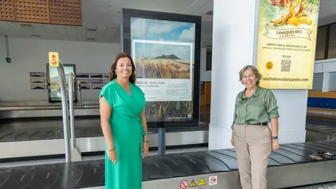 Olivia Duque y Rita Hern&aacute;ndez junto a un cartel promocional de Teguise.