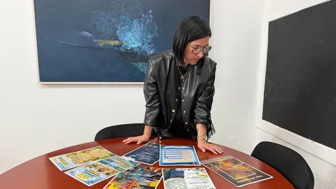 Abigail Gonz&aacute;lez junto a los carteles promocionales de los actos culturales.