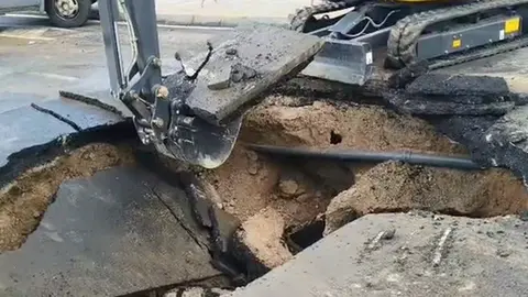 Pala excavadora abriendo un agujero donde se encuentra la tuber&iacute;a afectada.