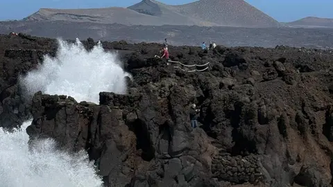 Personas en la zona de los Hervideros durante el fuerte oleaje.
