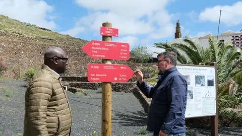 Isidro P&eacute;rez junto a Mamadou Yero Sy Ciss&eacute; observando la carteler&iacute;a de senderos municipales.