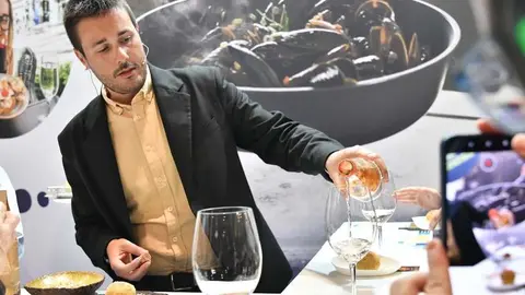 Jorge Rodríguez sirviendo vino en un evento. 