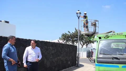 &Oacute;scar Noda y &Aacute;ngel Lago junto a los operarios colocando farolas en Yaiza.