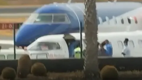 Momento difundido por Televisi&oacute;n Espa&ntilde;ola de la subida de los pasajeros del barco infectados en un avi&oacute;n medicalizado.
