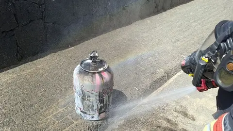 Bomberos del Consorcio enfriando la bombona de gas en la que estaban localizadas las llamas.