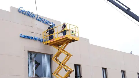 Operarios retirando el rotulado de Canal Gesti&oacute;n.
