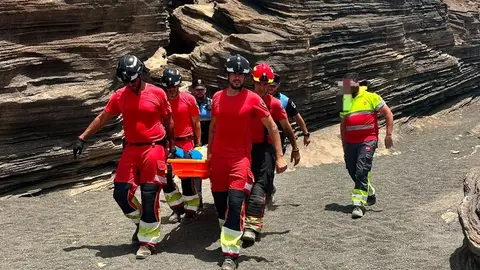 Momento en el que los bomberos y los polic&iacute;as locales trasladan a la persona herida.