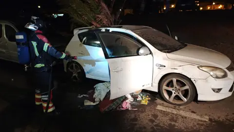 Bombero del Consorcio sofocando las llamas localizadas en el interior del veh&iacute;culo.