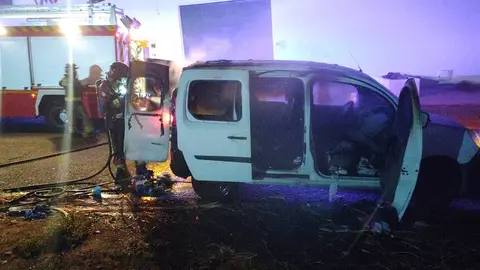 Bombero extinguiendo las llamas dentro del veh&iacute;culo.