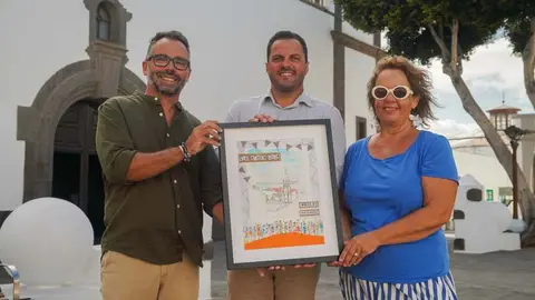 Echedey Eugenio y Yonathan de Le&oacute;n junto al cartel de San Gin&eacute;s y la artista que lo realiz&oacute;.