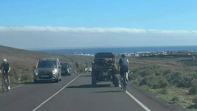 Coches adelantando a ciclistas y a buggies en la misma carretera