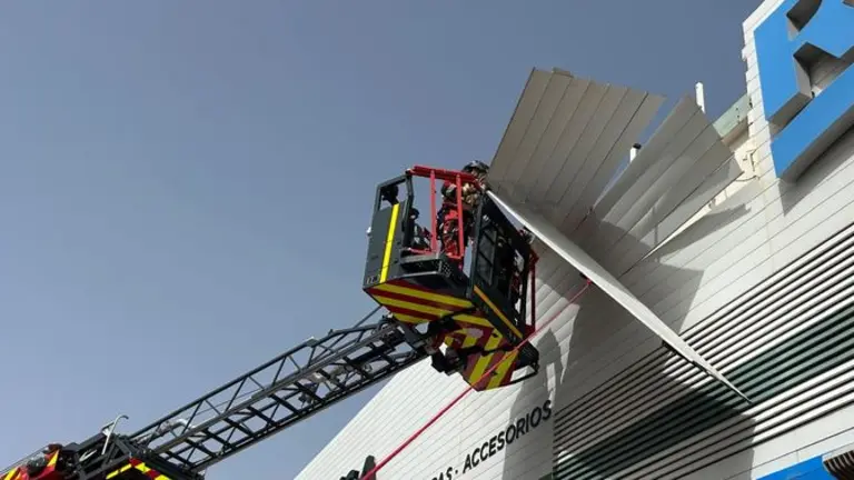 Imagen de los bomberos actuando en una fachada de un conocido comercio de Playa Honda