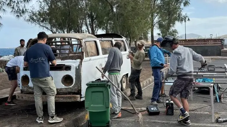 La gente trabajando a destajo en la reconstrucci&oacute;n de la furgoneta Volkswagen que hace las veces de bar en Arrieta