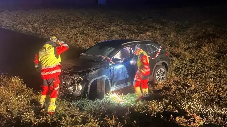 Bomberos junto al veh&iacute;culo accidentado.